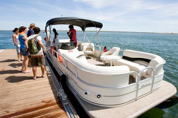 a group of people in a boat on the beach
